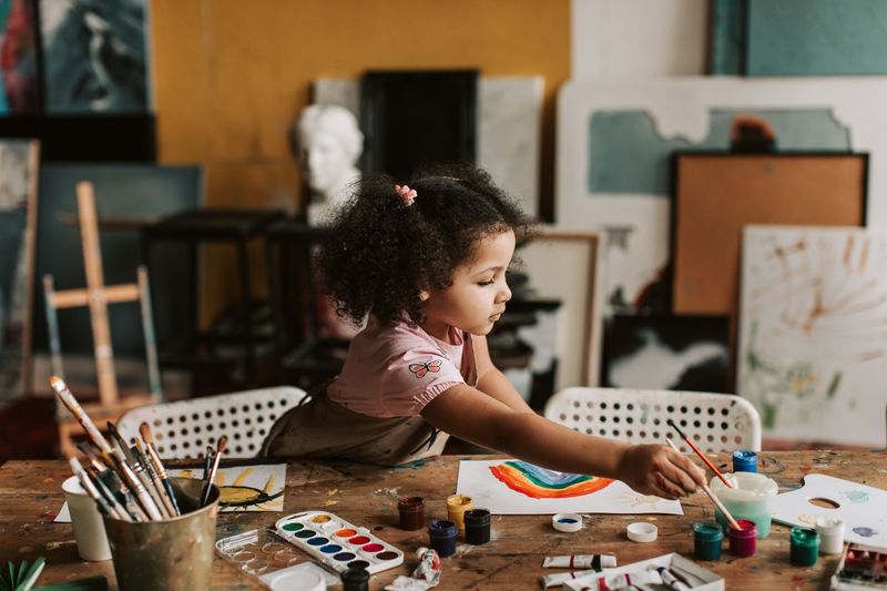 Daycare caregiver serving a child a child-friendly meal in a warm home setting