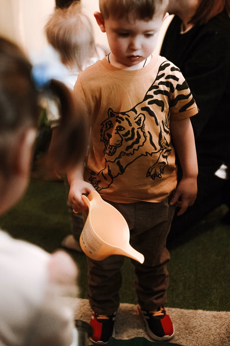 Toddler exploring a supervised sensory bin activity at an in-home daycare