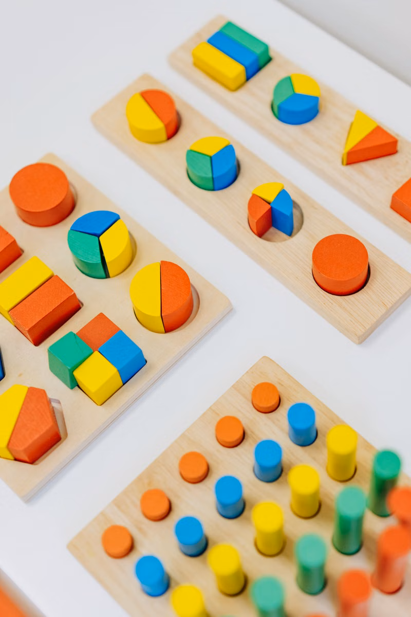 Child sorting colorful shapes during an educational daycare activity